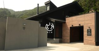 緑豊かな山々を背景に建つモダンな宿泊施設「RIN」の外観