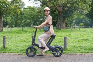 公園で笑顔で電動スクーターに乗る女性