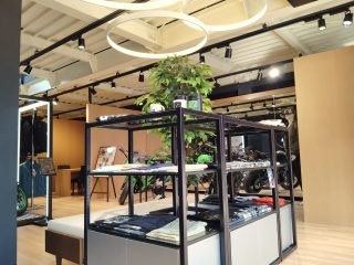 アパレルとバイクが展示されたアイランドディスプレイ