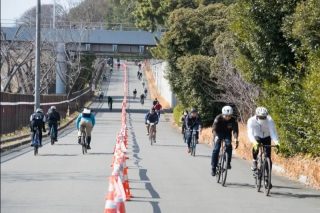 多くの人々が自転車に乗って坂道を上っている様子