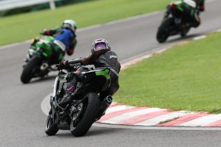 レーシングスーツを着たライダーがカーブを曲がる様子