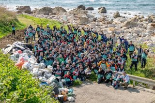 海岸清掃活動をする人々の集合写真