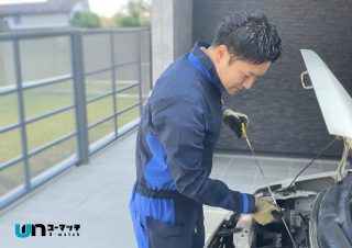 整備士が車のボンネットを点検している様子