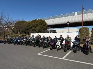多くのライダーたちが様々なバイクに跨り、駐車場に整列