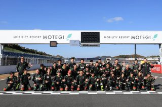 モビリティリゾートもてぎのサーキットで集合写真を撮る人々