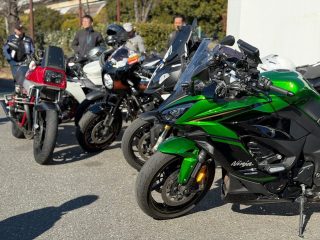 晴れた日に屋外に駐車された複数のバイクとライダーたち