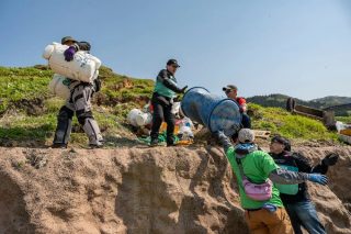 屋外でゴミを回収する人々