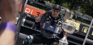 Monster Energyのキャップをかぶりトロフィーを持って勝利を祝うマイケル・ダンロップ選手