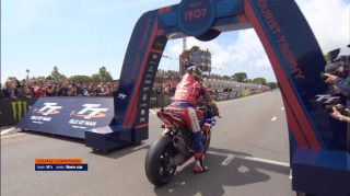 マン島TTレースのスタートラインらしき場所でオートバイに乗るライダー