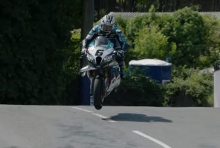 公道の起伏を乗り越え宙に浮き上がるバイクとライダー