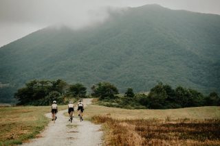 霧に覆われた山々を背景にサイクリング