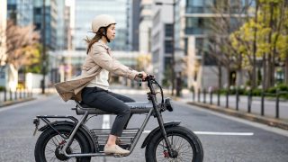 女性が電動自転車に乗っている街中の風景