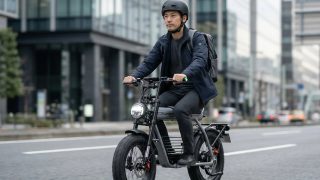 男性が電動アシスト自転車に乗っている都市の風景