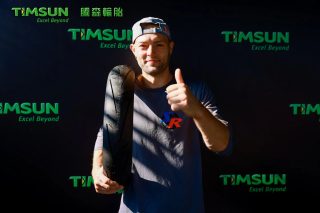 TIMSUNタイヤを抱えサムズアップする男性