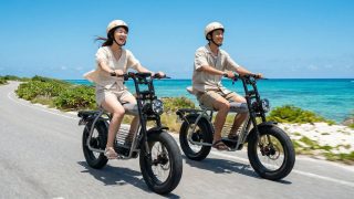 海沿いを電動バイクで走るカップル