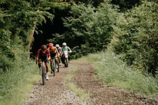 森の中のグラベルロードを進むサイクリスト