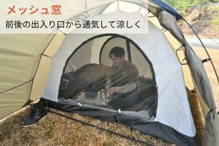 テントの中にいる男性がメッシュ窓から外を見ながら休憩しており、前後の出入り口からの通気で涼しく過ごせる様子