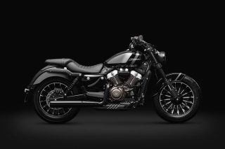 暗い背景に黒いクルーザータイプのオートバイ