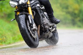 雨上がりの路面を走るバイク
