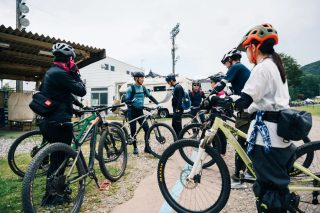 マウンテンバイクを囲んで集まる人々