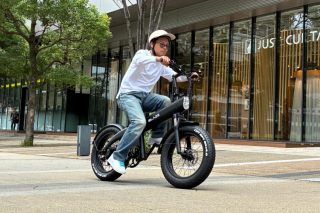 都会の街路で黒いファットタイヤの電動自転車に乗る男性