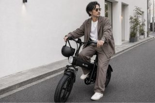 都会のストリートで、サングラスをかけた男性が黒い電動自転車に乗っています