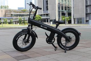 都会的な背景に、黒い電動ファットバイクが停車している様子