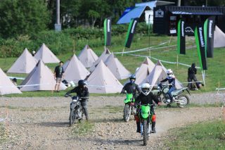 河原でオフロードバイクに乗る人々