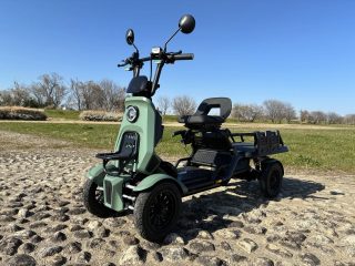 青空の下に停まるミントグリーンの三輪電動スクーター