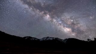 天の川が広がる夜空と山々