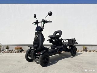 白い壁と青空を背景に、黒い四輪の電動スクーターが屋外に置かれています