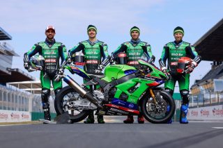 カワサキ製レーシングバイクとチームの集合写真