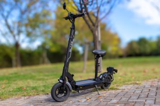 公園の石畳に停められた黒い電動スクーター