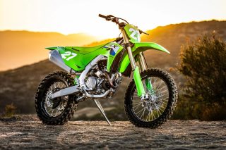夕焼けを背景に、鮮やかな緑色のカワサキKX250FXオフロードバイク