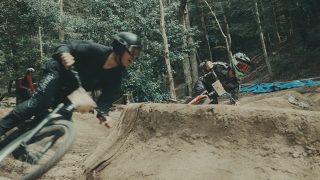 森林のダートコースでマウンテンバイクに乗る2人のライダー