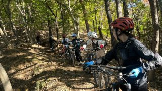 森の中で数人の女性がマウンテンバイクに乗っている様子