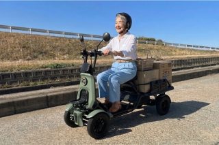 荷物を積んだ緑色のブレイズ イーカーゴを運転する高齢女性