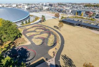 公園の航空写真。左に大きなドーム型施設、中央に波状のポンプトラックがある。