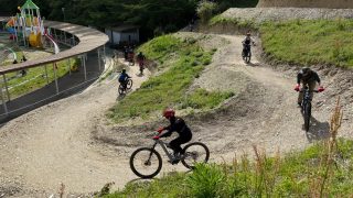 公園のダートコースでマウンテンバイクに乗る人々