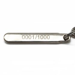 「0001/1000」とシリアルナンバーが刻印された金属製タグ
