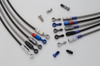 様々な種類のブレーキホース、フィッティング、バンジョーボルトが白い背景に並べられています。