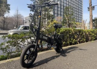 晴れた日の都会の歩道に停められた黒い折りたたみ電動自転車