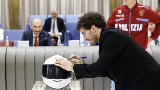 ヘルメットにサインする男性