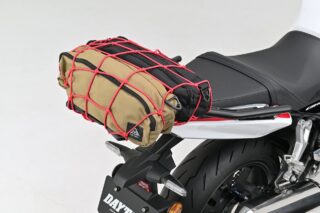 バイクのリアシートにカーキ色と黒色のバッグが積載され、赤いカーゴネットで固定