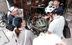 自転車の周りに集まり会話する人々