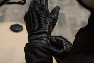 黒い革製のライディンググローブを着用した人物