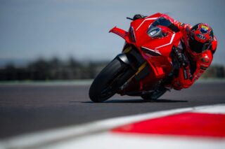赤いドゥカティレーシングバイクがサーキットを走行