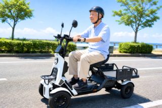 高齢男性が三輪電動スクーターに乗っている様子