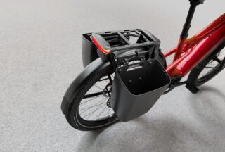 赤い自転車の後部に取り付けられたリアキャリアとパニアバッグ